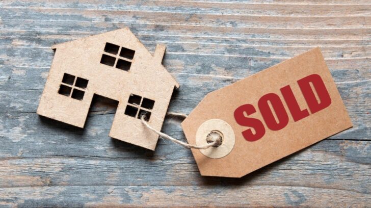 House model with a sold tag representing selling a house