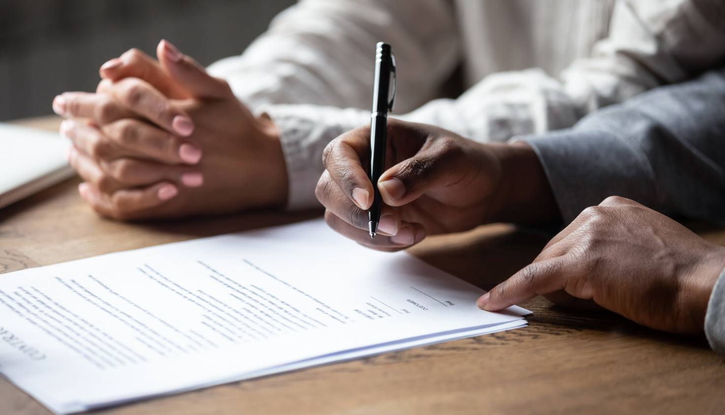 Older couple signing closing documents for selling a house in a trust before death