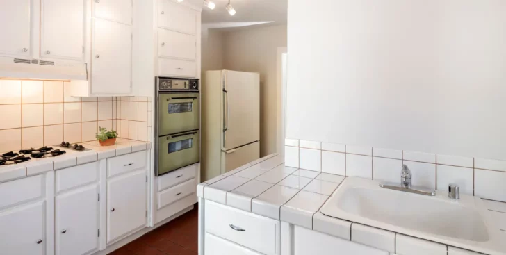 Dated kitchen interior representing a house that needs repairs