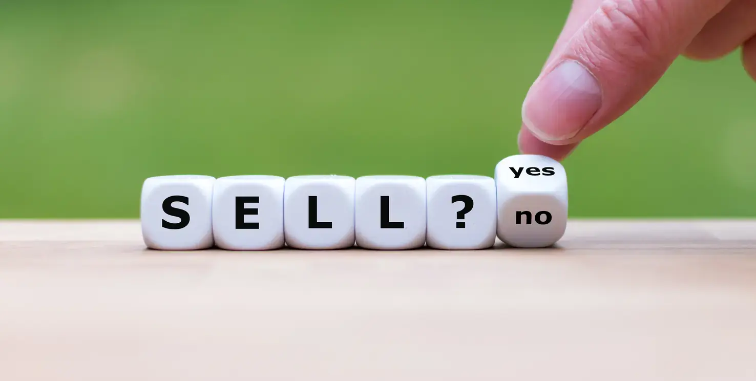 Blocks spelling sell with a yes or no choice, representing whether to sell a house now or wait