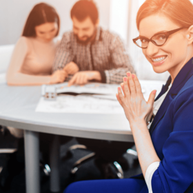 Smug real estate agent clasping hands while unsuspecting clients review documents.